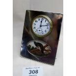 A silver desk clock with inset painting