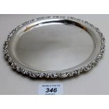 A silver salver with embossed edge, hallmarks worn, approx. 9.