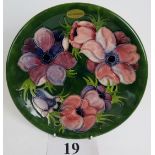 A Moorcroft cabinet plate, tube-lined with anemone on a green ground, painted and impressed marks,