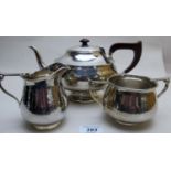 An Arts & Crafts silver hammered 3 piece tea service, with flower decoration to handles,