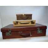 A large leather suitcase, a small pale leather document case and a small leather sewing case,