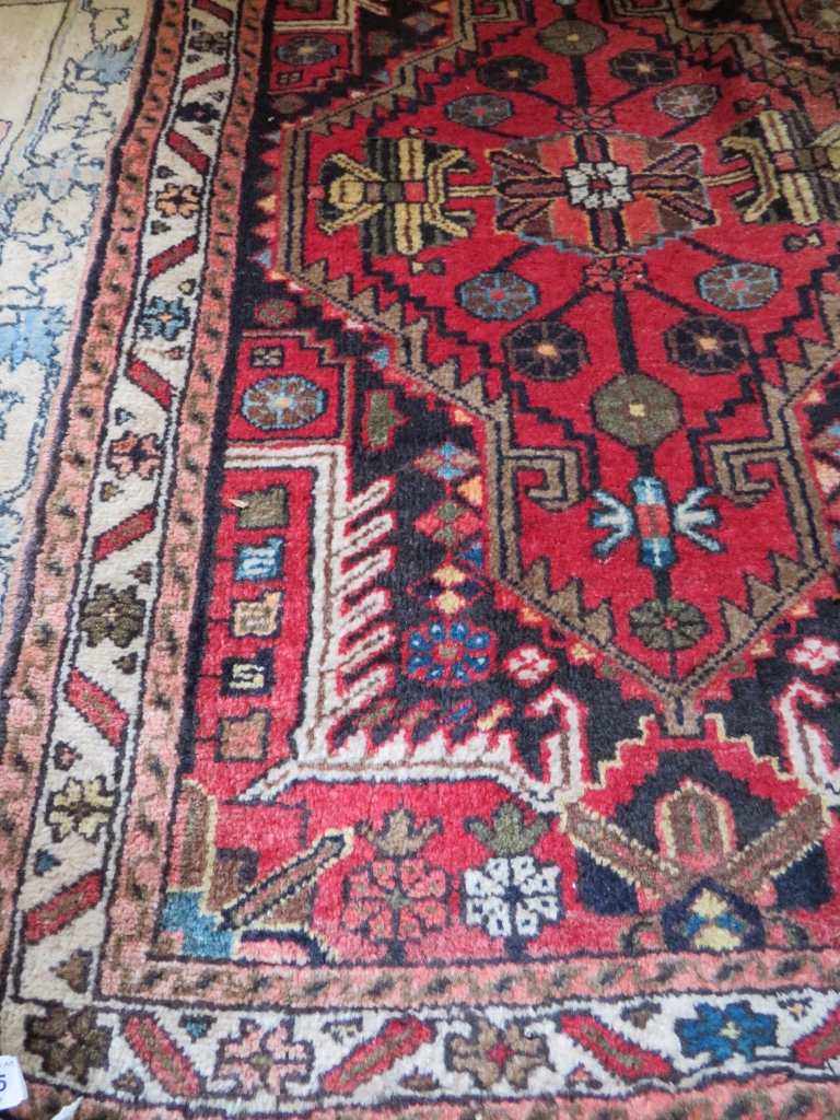 A good quality 20th century Persian rug on red ground,