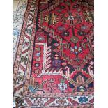 A good quality 20th century Persian rug on red ground,