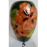 A contemporary Moorcroft vase, tube-lined with exotic flowers and foliage on a green ground,