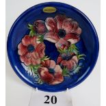 A Moorcroft cabinet plate, tube-lined with exotic flowers and foliage on a blue ground,