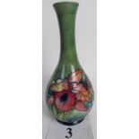 A Moorcroft bottle vase, c1960's, tube-lined with exotic flowers and foliage on a blue/green ground,