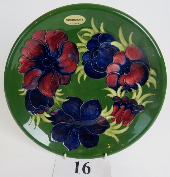 A Moorcroft cabinet plate, tube-lined with flowers and foliage on a green ground,