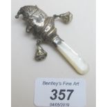 A babies silver rattle in the shape of Mr Punch with bells and mother of pearl handle,