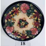 A Moorcroft cabinet plate, tube-lined with exotic flowers and foliage on blue/green/cream ground,