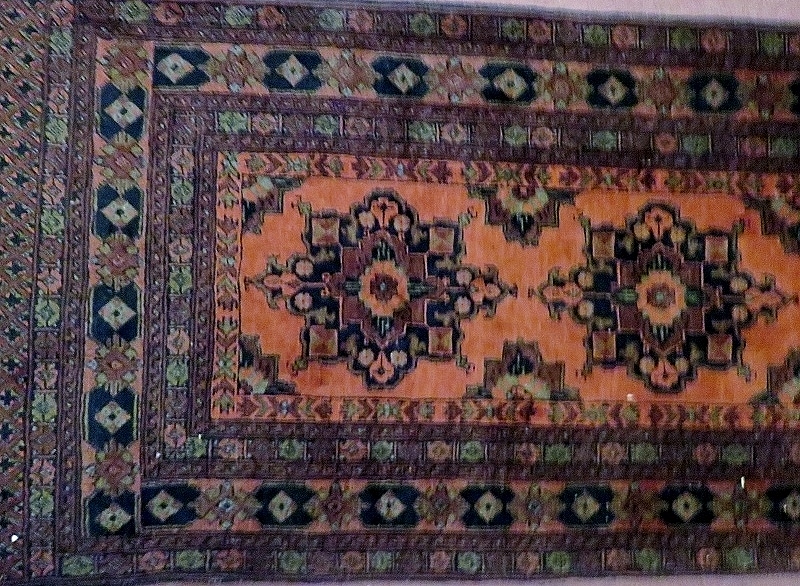 A mid 20th century Persian runner, burnt amber on brown field,