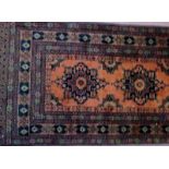 A mid 20th century Persian runner, burnt amber on brown field,