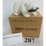 A contemporary white marble and jade sculpture, modelled as a bear with a fish in it's jaws,
