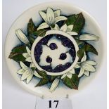 A Moorcroft cabinet plate, tube-lined with berries, flowers and foliage on a cream/bluey ground,