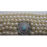 A fine quality 3 strand pearl necklace with diamond and opal clasp, each row approx.