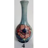 A Moorcroft bottle vase, tube-lined with flowers and foliage on a mottled blue ground,