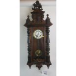 A 19th century wall clock in the style of a Swiss regulator, enamel dial, key & pendulum present,