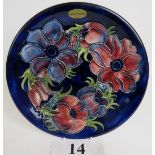 A Moorcroft cabinet plate, tube-lined with flowers and foliage on a blue ground,