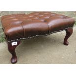 A 20th Century low footstool upholstered