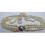 A three stone graduated pearl necklace with pearl and diamond clasp,