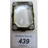 A small exquisite black enamelled frame inset with four groups of diamonds, representing flowers,