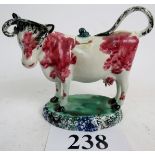 A late 18th/early 19th century Spongeware decorated pottery cow creamer, with cover,