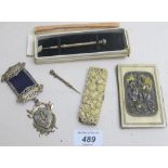 A boxed slide pencil, a slide toothpick, an ivory aide memoire, a carved clip and a silver medal.