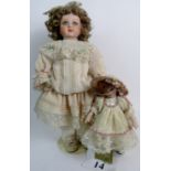 Two modern porcelain dolls, fully dressed in period style costumes,
