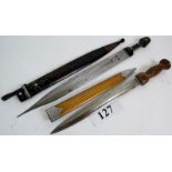 A vintage Eastern short sword with engraved blade, horn handle and studded leather sheath,