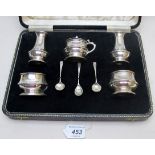 A five piece silver condiment set comprising of two peppers, two salts,