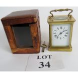 A 19th century brass carriage clock with key and outer leather case,