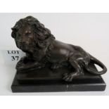 A contemporary bronze statue of a recumbent lion on a marble plinth, 12" wide,