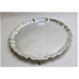 A silver salver with pie crust edge and