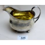 A Georgian silver jug on ball feet, with