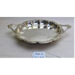 A two handled silver dish on ball feet,