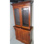 A late Victorian walnut bookcase with arched glazed doors, over arched panelled doors,