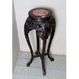 A c1900 carved Chinese jardiniere stand, with an inset red marble top,