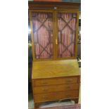 An Edwardian mahogany inlaid bureau bookcase with astral glazed top,