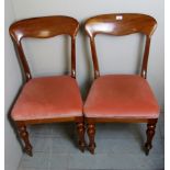 A pair of Victorian mahogany dining chairs upholstered in pink,