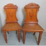A fine pair of Victorian pale oak hall chairs,
