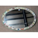 An oval framed painted wall mirror decorated with insects/butterflies,