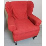 A 20th century small winged back armchair with loose pink covers est: £20-£40