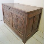 An 18th century carved oak coffer with planked top over carved panels,