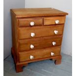 A small apprentice style pale oak chest of two short over three long drawers with glass handles