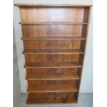 A solid honey oak bespoke open bookcase with six shelves and an open end,