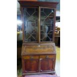 A late 19th/20th century flame mahogany bureau bookcase with astral glazed doors over fitted