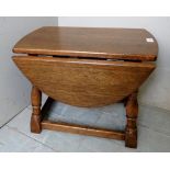 A late 20th century oak small drop leaf occasional table with oval top,