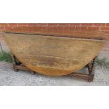 A large 18th/19th century oak oval gate leg dining table, with end drawer and bobbin turned legs,