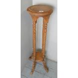 A pale pine/beech torchere stand with spiral twist supports,