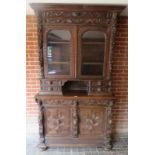 A large 19th century Flemish bookcase with carved lion mask, fruit, birds and figures,