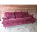 A large comfortable three seater sofa, upholstered in a soft maroon, duck feather filled upholstery,